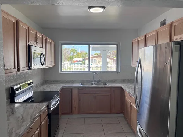 a kitchen with granite countertop cabinets stainless steel appliances and a sink