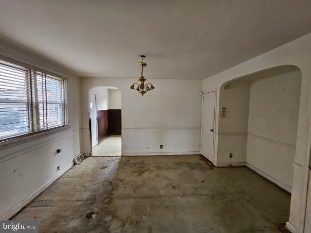 a view of a livingroom with a chandelier fan and windows