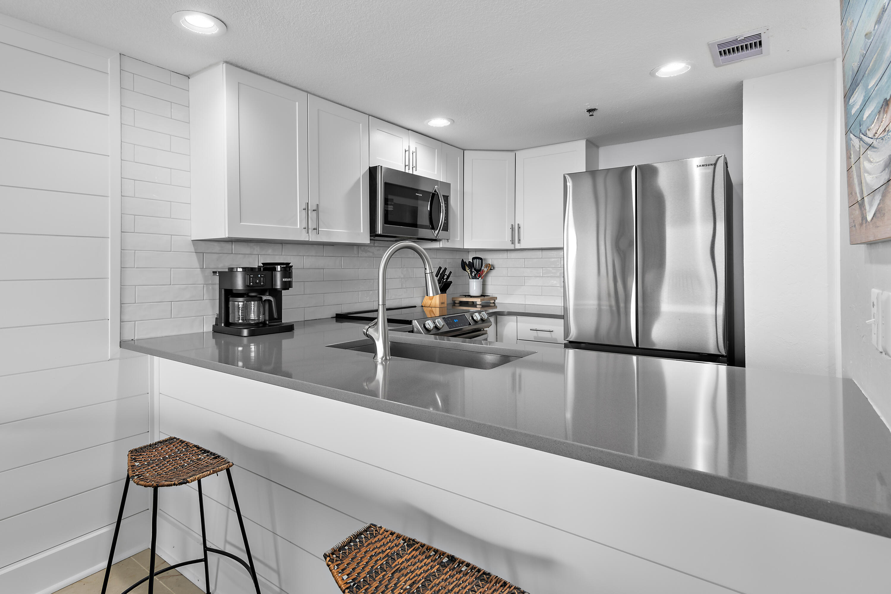 4100 East County Highway 30A, Unit 1805 Santa Rosa Beach, FL 32459 - Photo 4 of 35 a kitchen with a refrigerator a sink and white cabinets