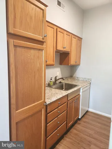 a kitchen with a sink cabinets and a wooden floor