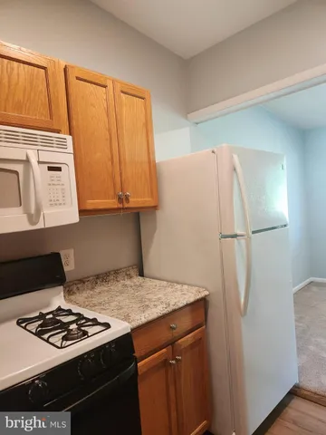 a kitchen with stainless steel appliances granite countertop a refrigerator and a stove