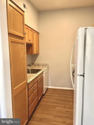 a view of a kitchen with a sink and refrigerator