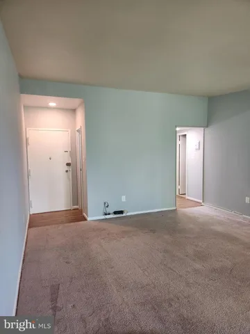 a view of an empty room with window and closet area