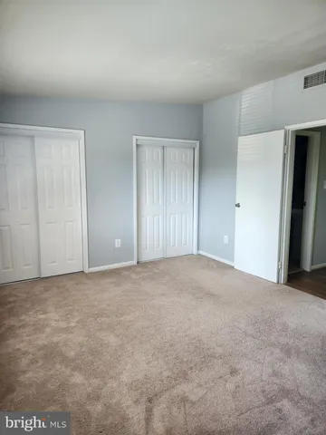 a view of an empty room and closet area