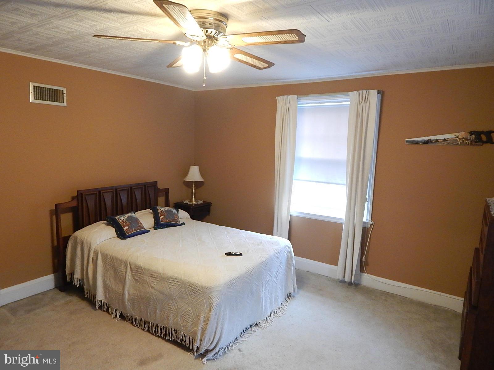 7623 Philadelphia Road Baltimore, MD 21237 - Photo 16 of 28 a bedroom with a bed and a chandelier