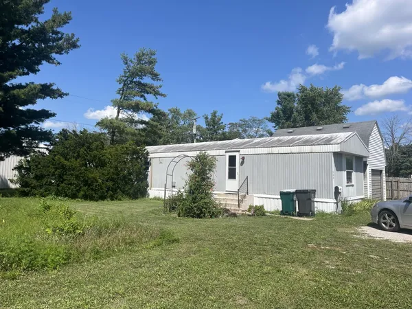 a view of a house with backyard and a garden