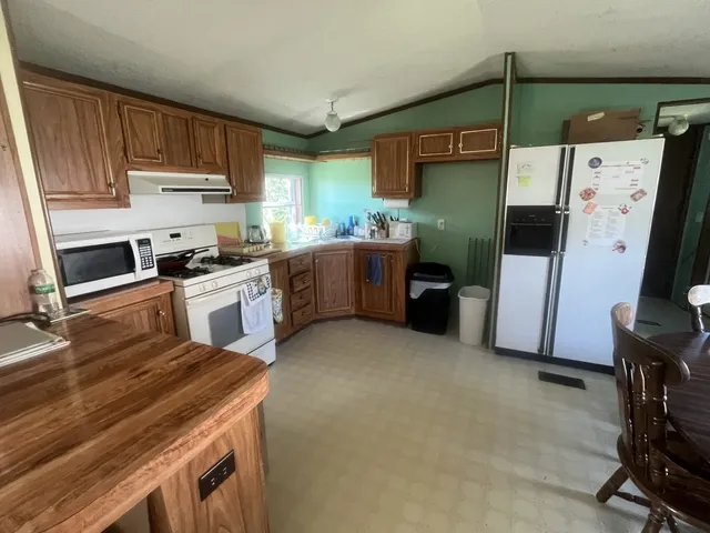 a kitchen with cabinets and chairs