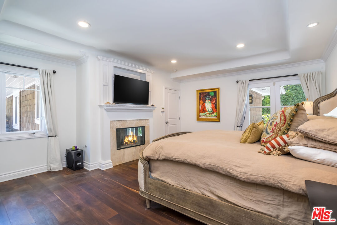 919 Chantilly Road Los Angeles, CA 90077 - Photo 12 of 23 a bedroom with a bed and a flat screen tv