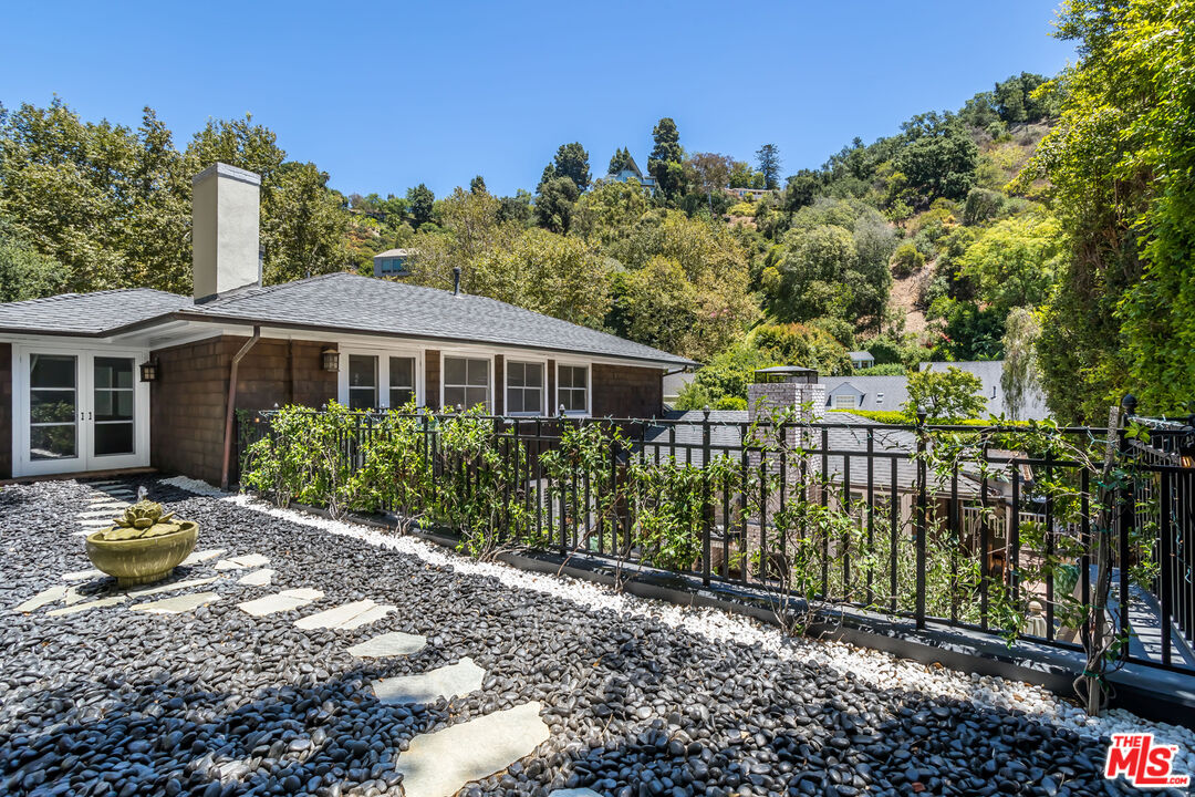 919 Chantilly Road Los Angeles, CA 90077 - Photo 22 of 23 a front view of a house with a garden