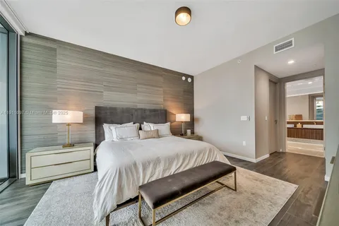 a bedroom with a bed and a view of living room