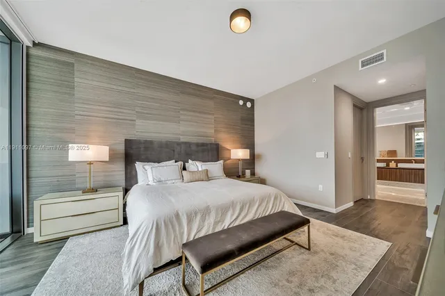 a bedroom with a bed and a view of living room