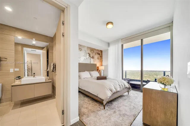 a bedroom with a bed and large windows