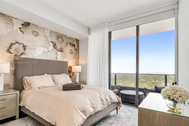 a bedroom with a bed and large windows