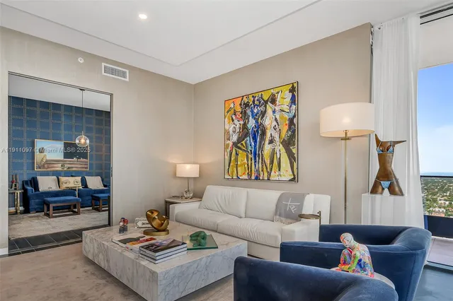 a living room with furniture and a painting on the wall