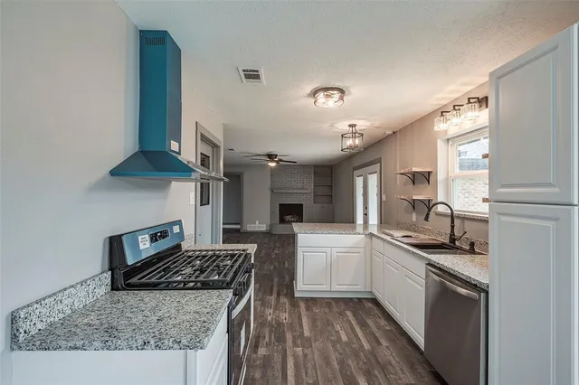 a kitchen with stainless steel appliances granite countertop a stove a sink and a refrigerator