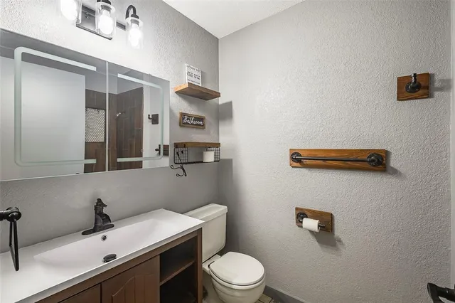 a bathroom with a sink a toilet and mirror