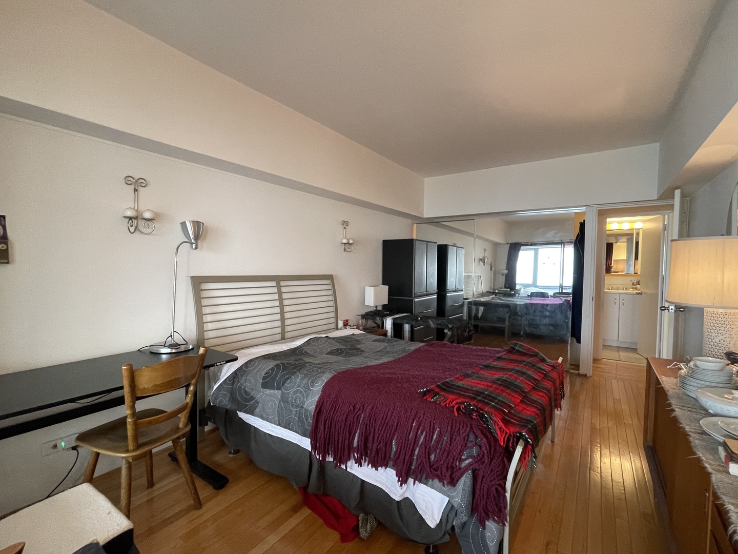 175 East Delaware Place, Unit 5604 Chicago, IL 60611 - Photo 13 of 21 a bedroom with a bed a lamp on dresser and a chandelier