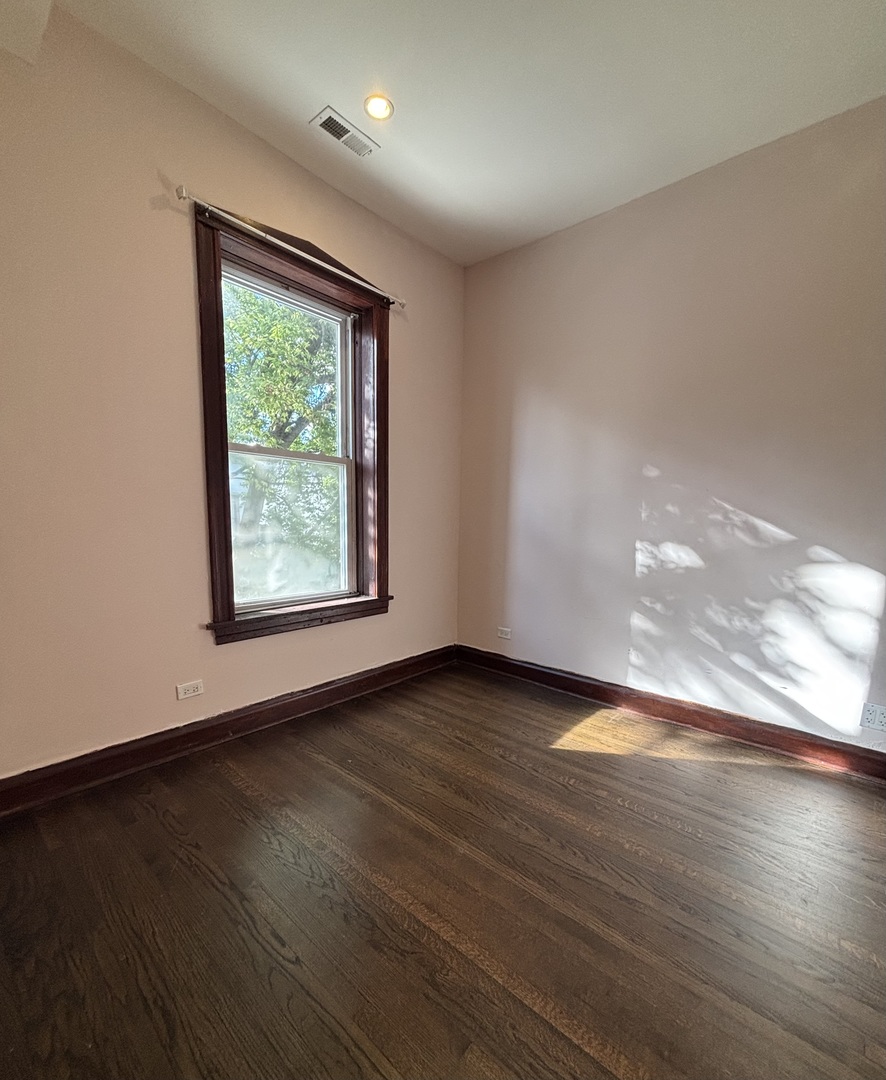 3133 North Richmond Street, Unit 2 Chicago, IL 60618 - Photo 11 of 16 an empty room with wooden floor and windows