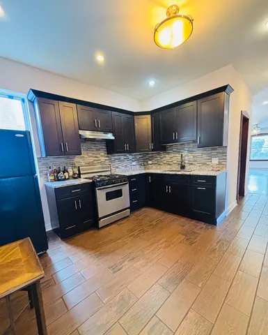 a kitchen with stainless steel appliances granite countertop a stove a sink and a refrigerator