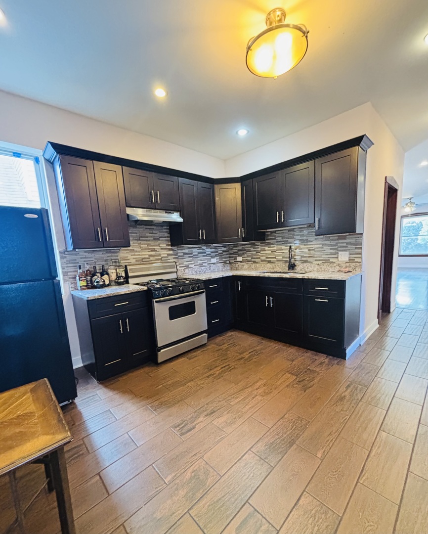 3133 North Richmond Street, Unit 2 Chicago, IL 60618 - Photo 2 of 16 a kitchen with stainless steel appliances granite countertop a stove a sink and a refrigerator