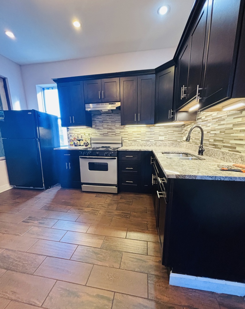 3133 North Richmond Street, Unit 2 Chicago, IL 60618 - Photo 4 of 16 a kitchen with stainless steel appliances granite countertop a sink stove and cabinets