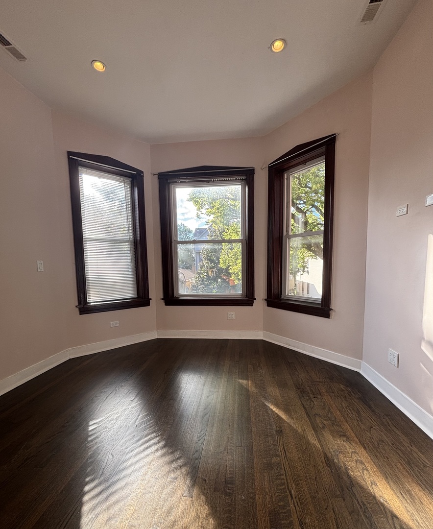 3133 North Richmond Street, Unit 2 Chicago, IL 60618 - Photo 7 of 16 an empty room with wooden floor and windows