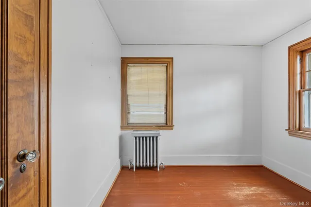 an empty room with wooden floor and closet