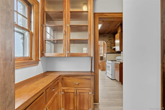 a view of an empty room with wooden floor and stairs