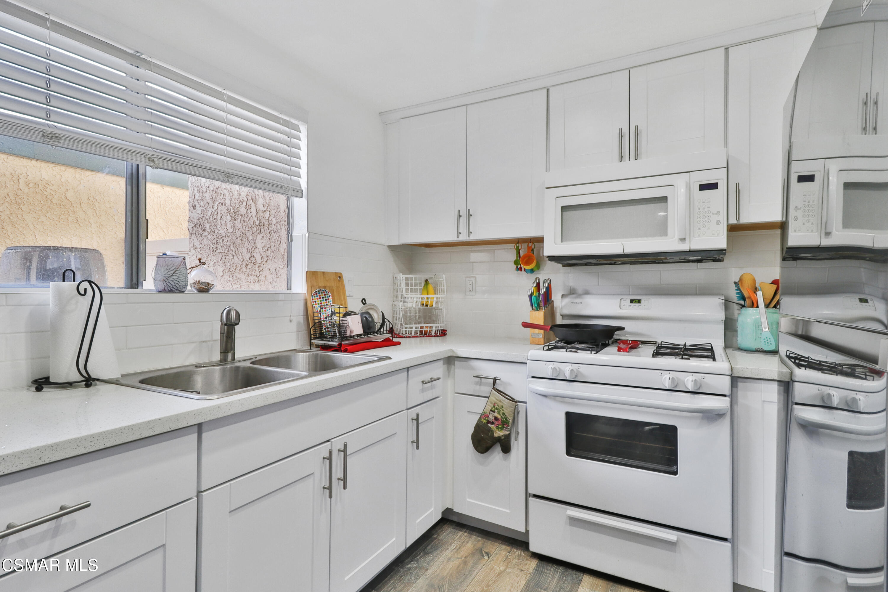 5239 Perkins Road Oxnard, CA 93033 - Photo 6 of 25 a kitchen with white cabinets sink and white appliances