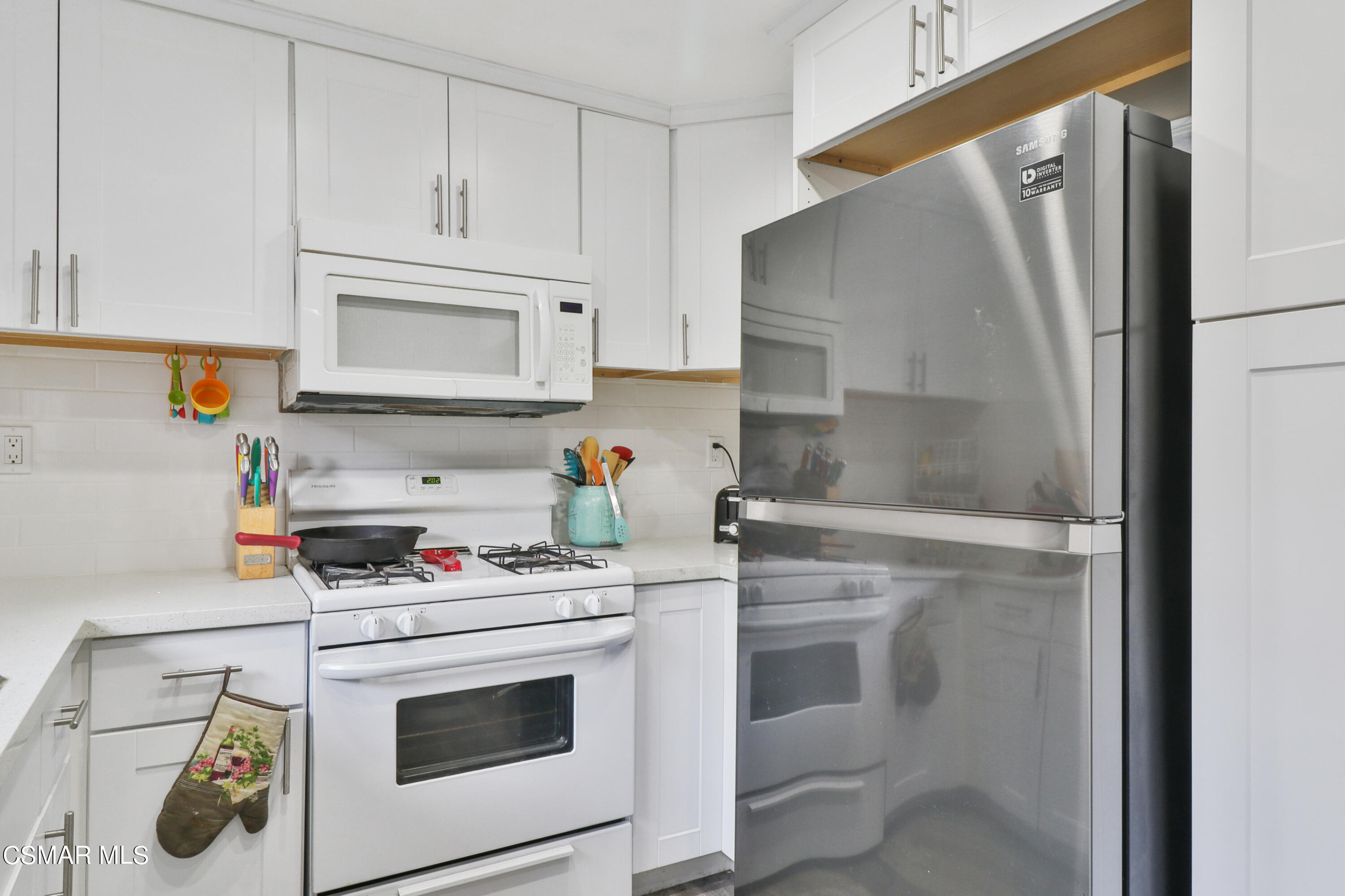 5239 Perkins Road Oxnard, CA 93033 - Photo 7 of 25 a kitchen with white cabinets and white appliances