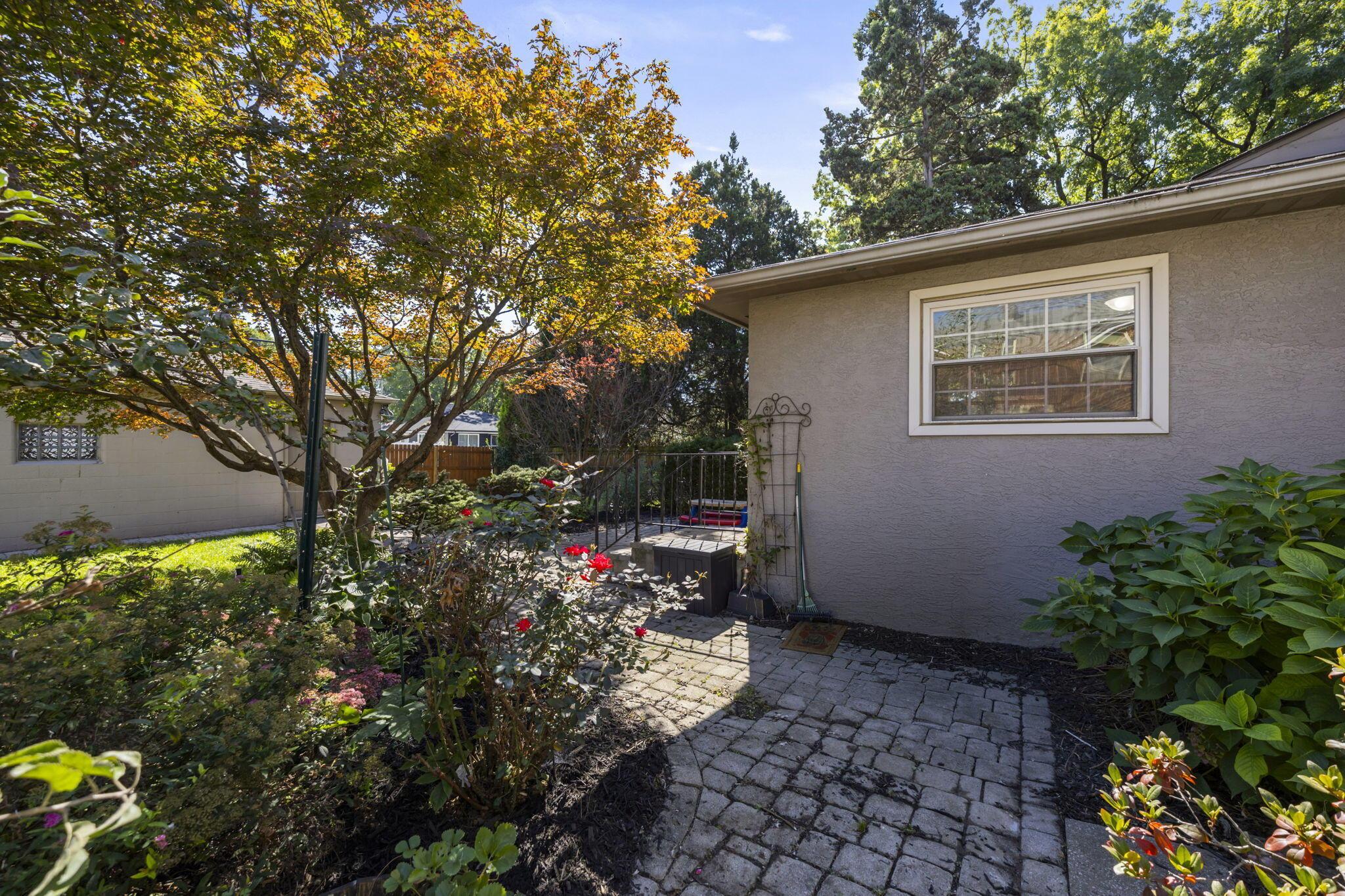 40 South Kellner Road Columbus, OH 43209 - Photo 46 of 57 Paved stone patio featuring an ornamental trellis, surrounded by established landscaping and mature trees