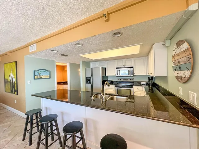 a kitchen with stainless steel appliances granite countertop a sink and cabinets