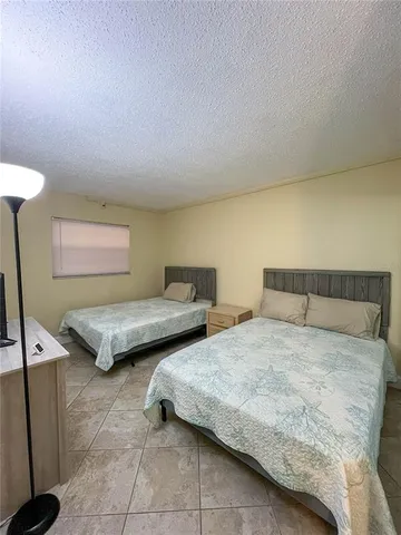 a bedroom with two beds and a lamp