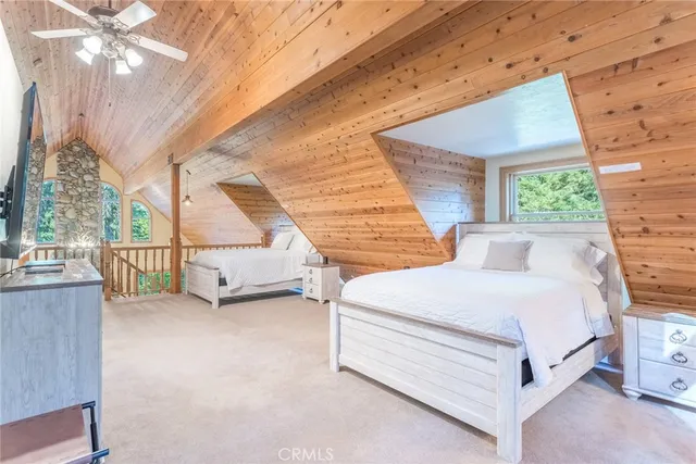 a spacious bedroom with a bed a couch and large window