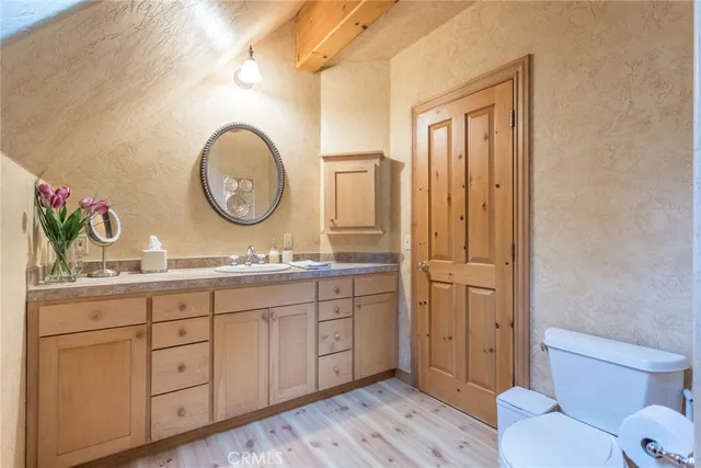 a bathroom with a granite countertop sink mirror vanity and toilet