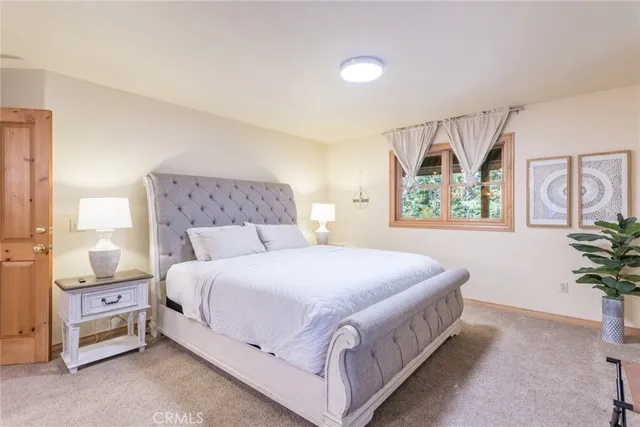 a bedroom with a large bed and a potted plant