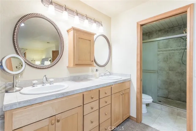 a bathroom with a granite countertop double vanity sink and a mirror