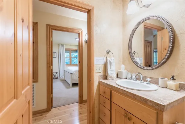 a en suite bathroom with a granite countertop sink and a mirror