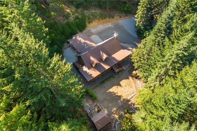 an aerial view of a house with a garden and lake view