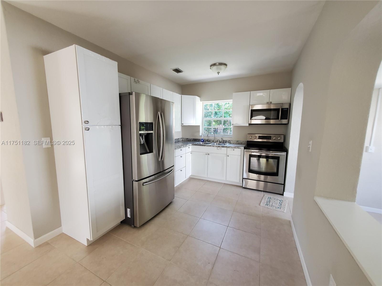 70 Northwest 33rd Street Miami, FL 33127 - Photo 13 of 48 a kitchen with stainless steel appliances granite countertop a refrigerator and a sink