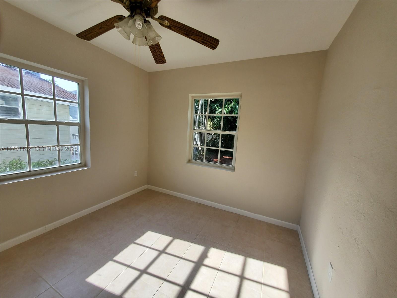 70 Northwest 33rd Street Miami, FL 33127 - Photo 26 of 48 an empty room with windows and ceiling fan