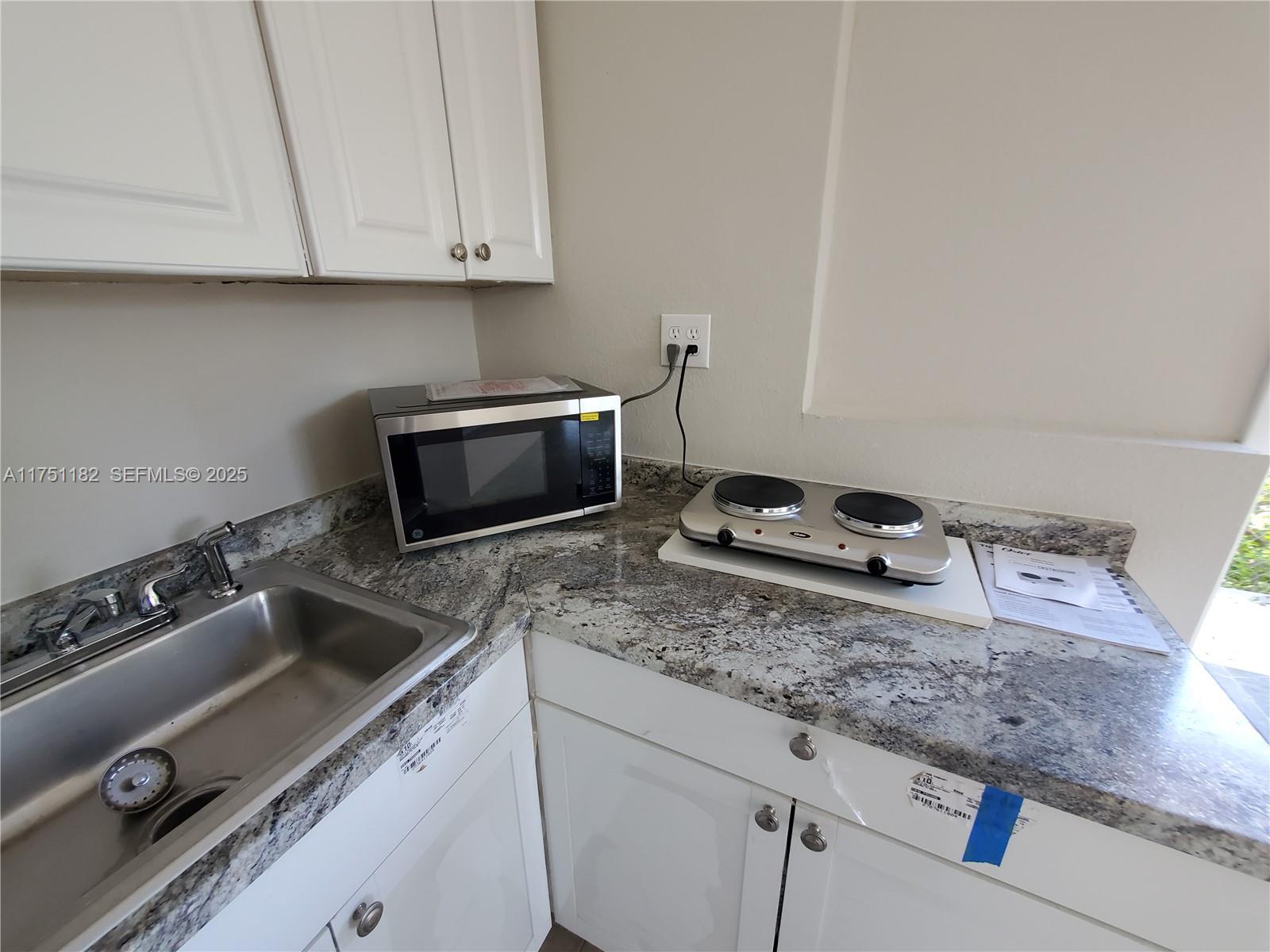 70 Northwest 33rd Street Miami, FL 33127 - Photo 39 of 48 a kitchen with granite countertop a stove and a sink