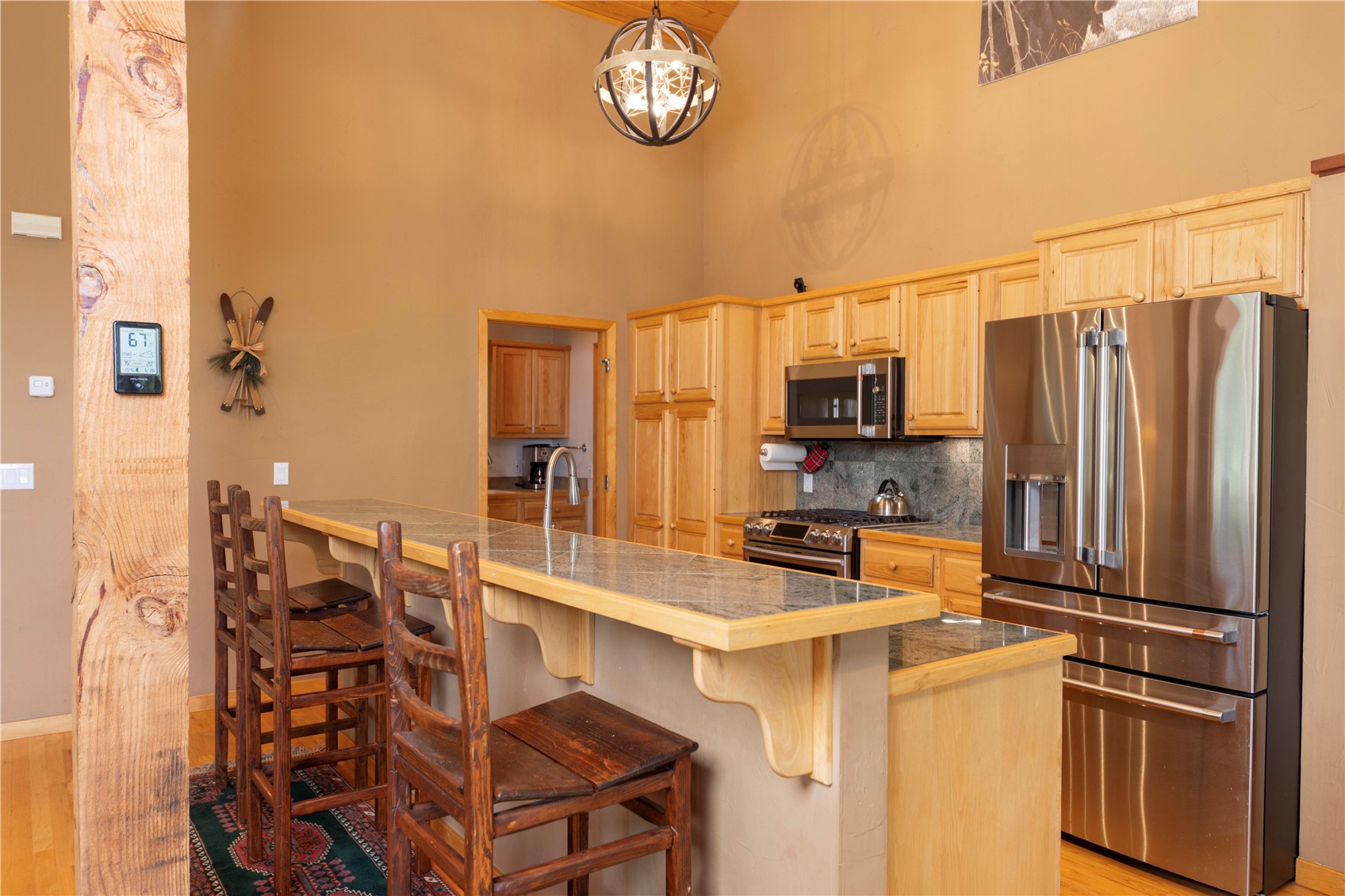 760 Penstemon Road Keystone, CO 80435 - Photo 9 of 39 Kitchen with appliances with stainless steel finishes, a towering ceiling, light hardwood / wood-style floors, and a breakfast bar