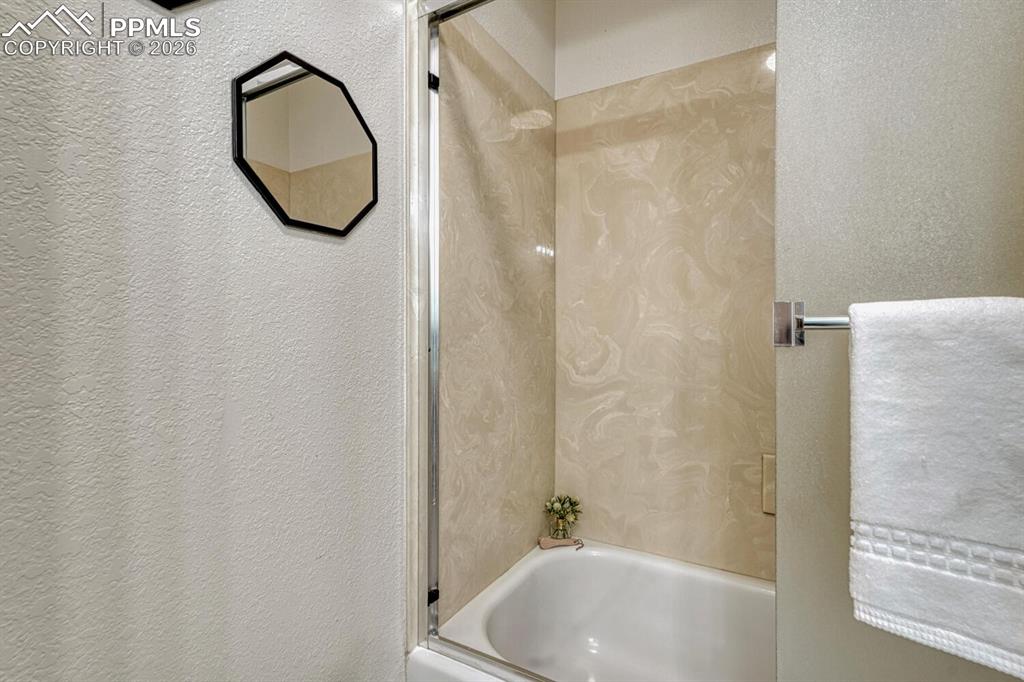 15430 Bar X Road Colorado Springs, CO 80908 - Photo 27 of 50 a bathroom with a tub a window and a sink