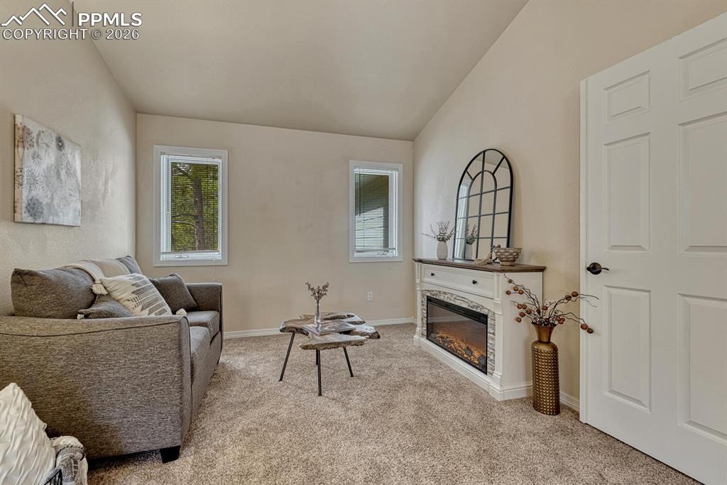 15430 Bar X Road Colorado Springs, CO 80908 - Photo 29 of 50 a living room with furniture and a fireplace