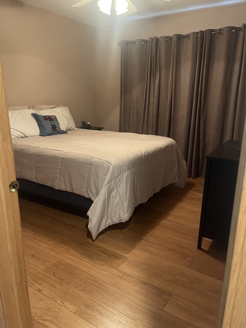 142 Sedgewicke Drive Romeoville, IL 60446 - Photo 5 of 18 a bedroom with a bed and wooden floor