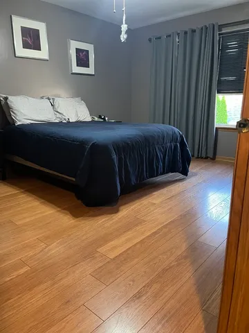 a bedroom with a bed lamp and a large window