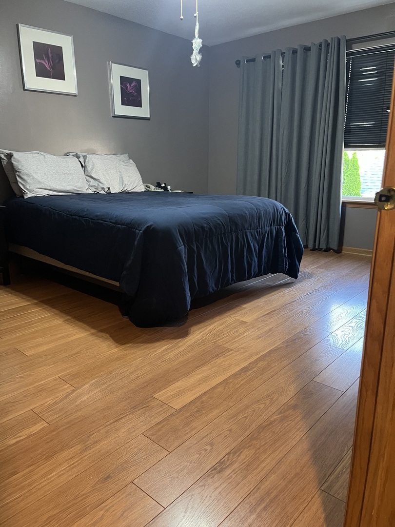 142 Sedgewicke Drive Romeoville, IL 60446 - Photo 7 of 18 a bedroom with a bed lamp and a large window