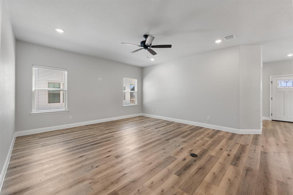 1568 Reverie Road Burleson, TX 76028 - Photo 14 of 26 an empty room with wooden floor ceiling fan and windows