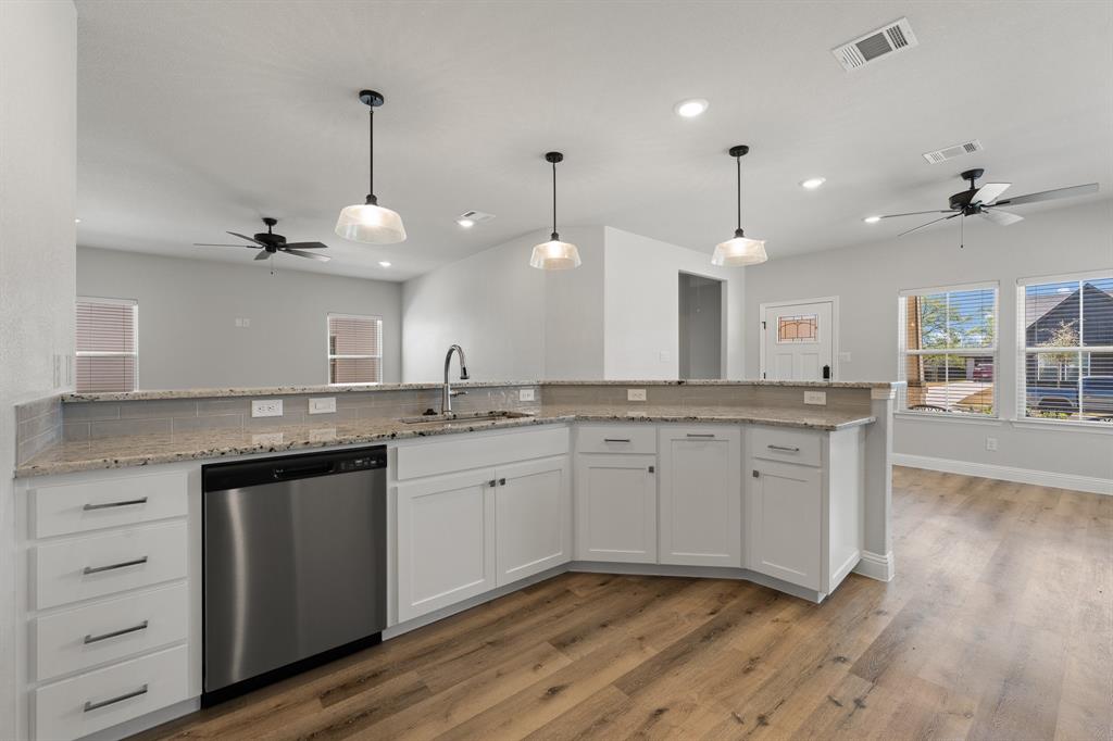 1568 Reverie Road Burleson, TX 76028 - Photo 7 of 26 a kitchen with granite countertop a sink cabinets and wooden floor